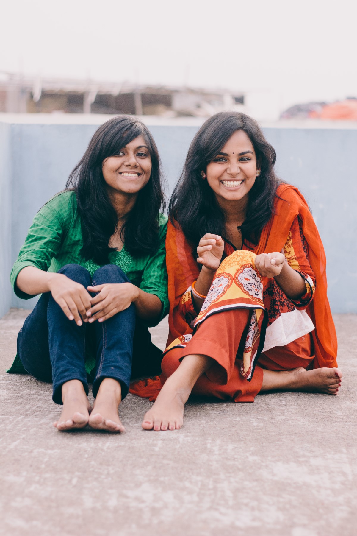 Two young women sitting and smiling together